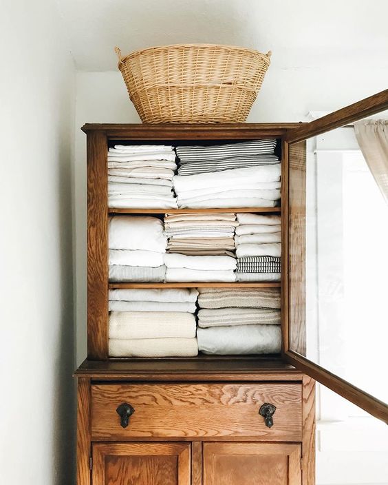 midsummer hygge | linen cabinet vintage wood rattan basket organization | Girlfriend is Better