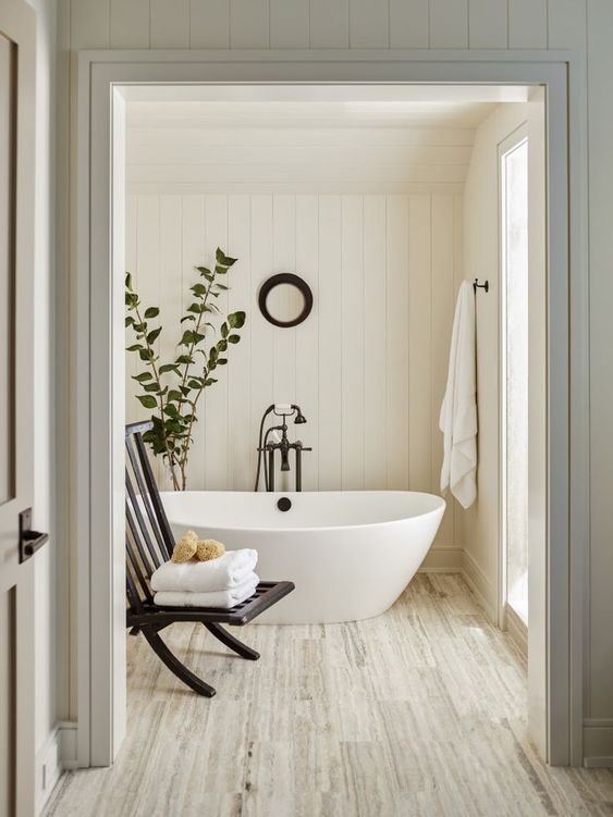 white interiors | pedestal bathtub natural wood flooring spa hygge bathroom | Girlfriend is Better