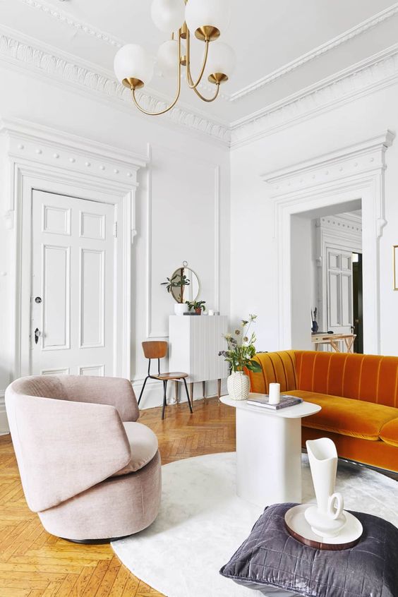 Parisian art deco | orange sofa herringbone flooring wall moulding modern chandelier | Girlfriend is Better